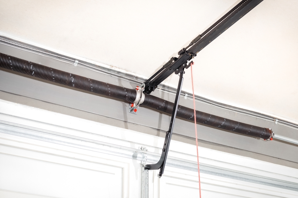 Close-up of a garage door torsion spring mounted above the door