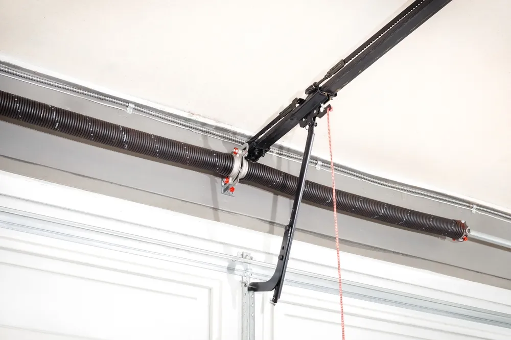 Close-up of a garage door torsion spring mounted above the door